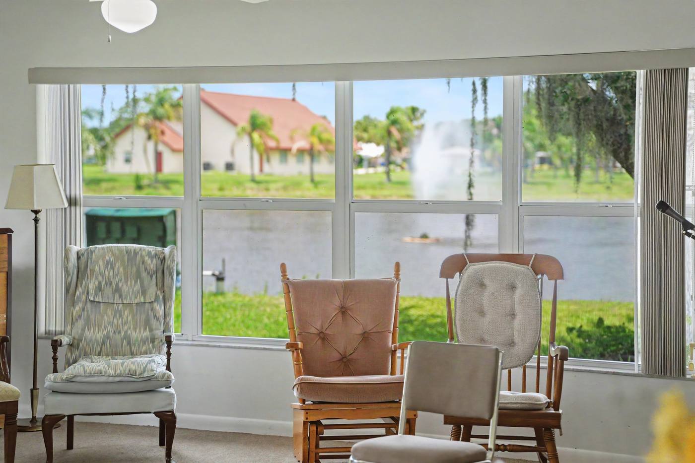 Rocking chairs by a window looking out to the lake and chapel