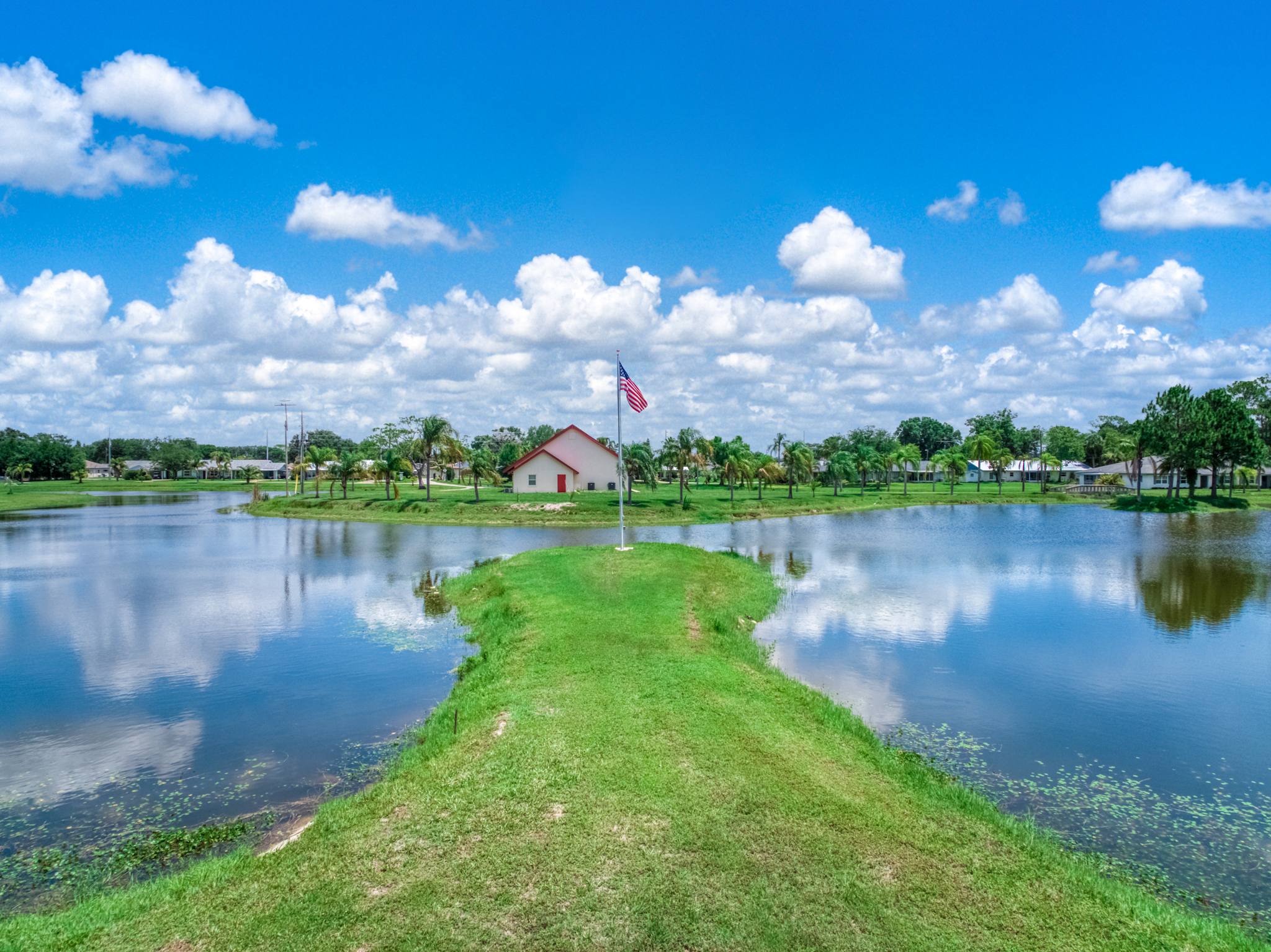 The grassy peninsula with its flagpole, leading to the chapel across the water